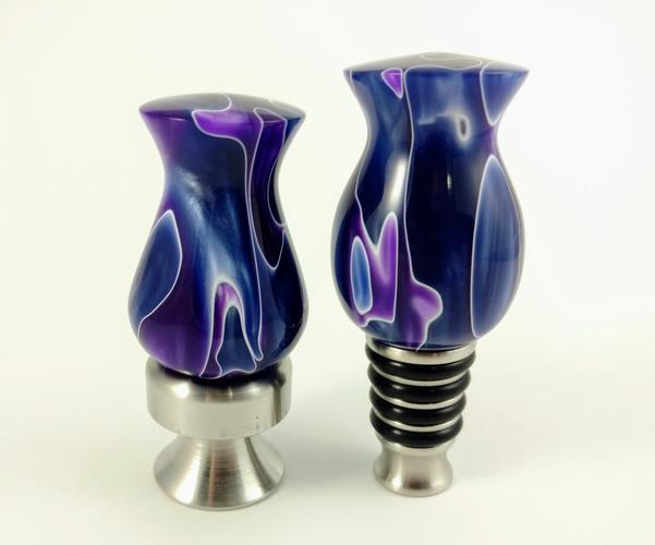 Turned acrylic handles for stainless steel bottle stopper and bottle opener. The acrylic has a wavy purple and blue pattern. 