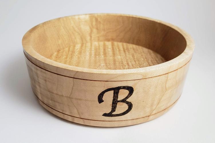 Turned wooden bowl with a burned letter 