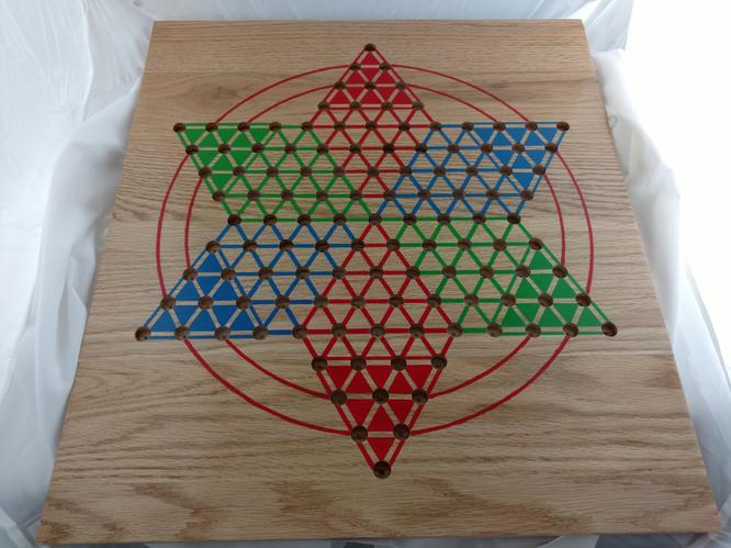 Chinese Checkers board painted in the style of my grandmother's board with red, blue, and green triangles and two red rings.